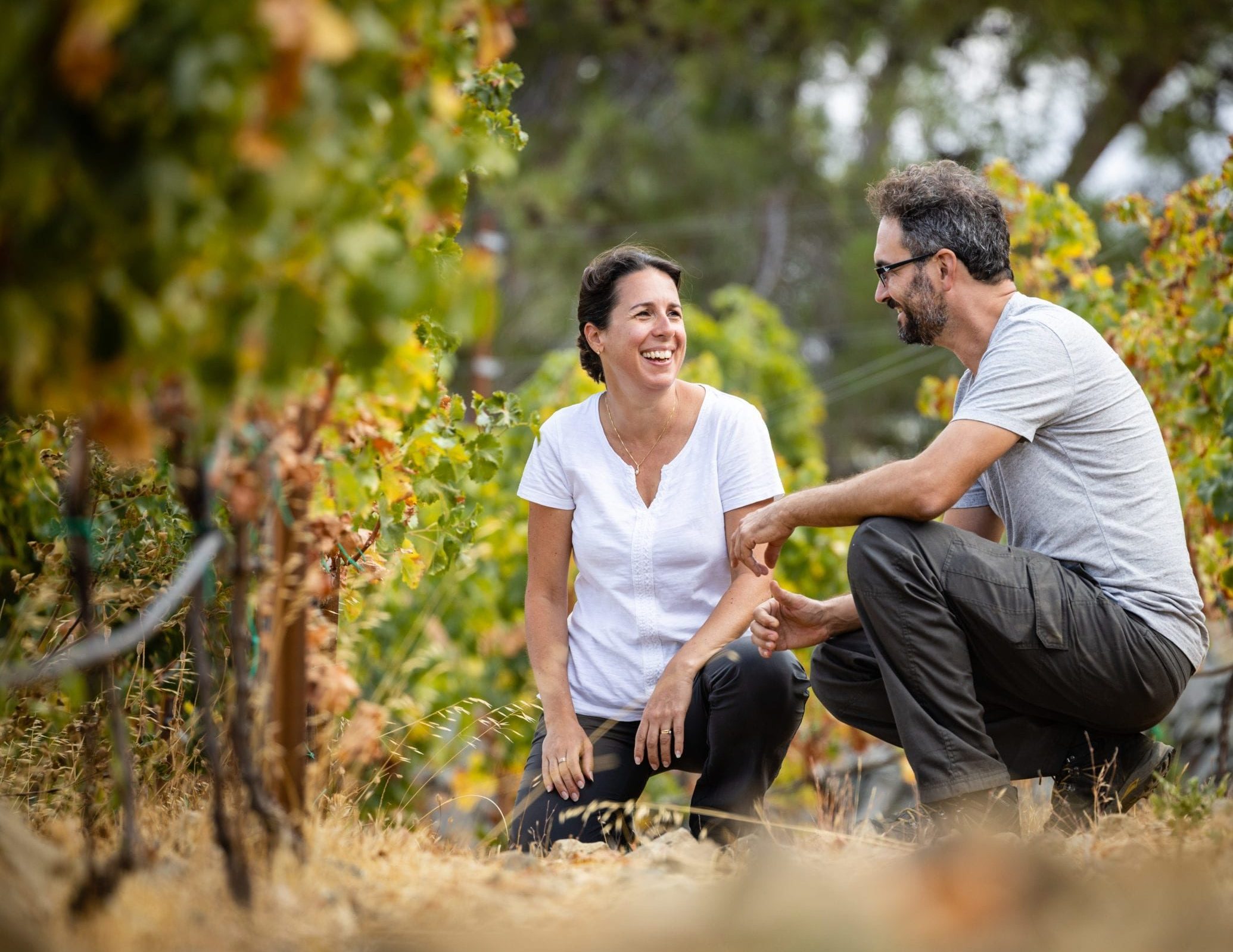 Victoras Finopoulos and Alexa Papadouris in the vineyards of Marathasa smiling and land