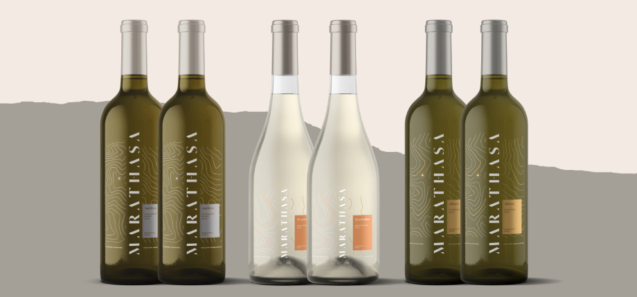 Six wine bottles are displayed in a row. Four are green with "MARTHASA" written vertically on the labels, and two are clear with white wine and orange label accents. The background is beige with a grey section behind the bottles.